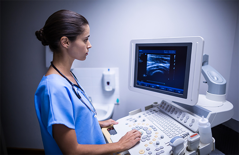 Nurse examining ultrasonic monitor in hospital